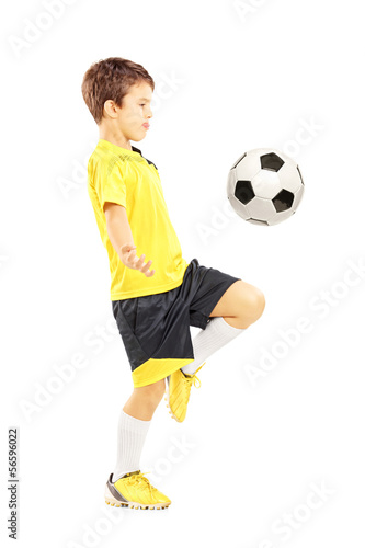Child in sportswear joggling with a soccer ball