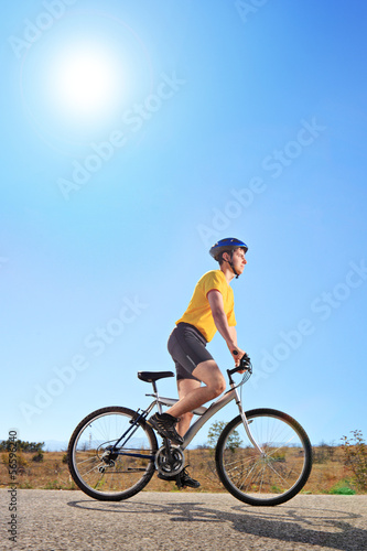Young male with helmet riding a bike outdoors
