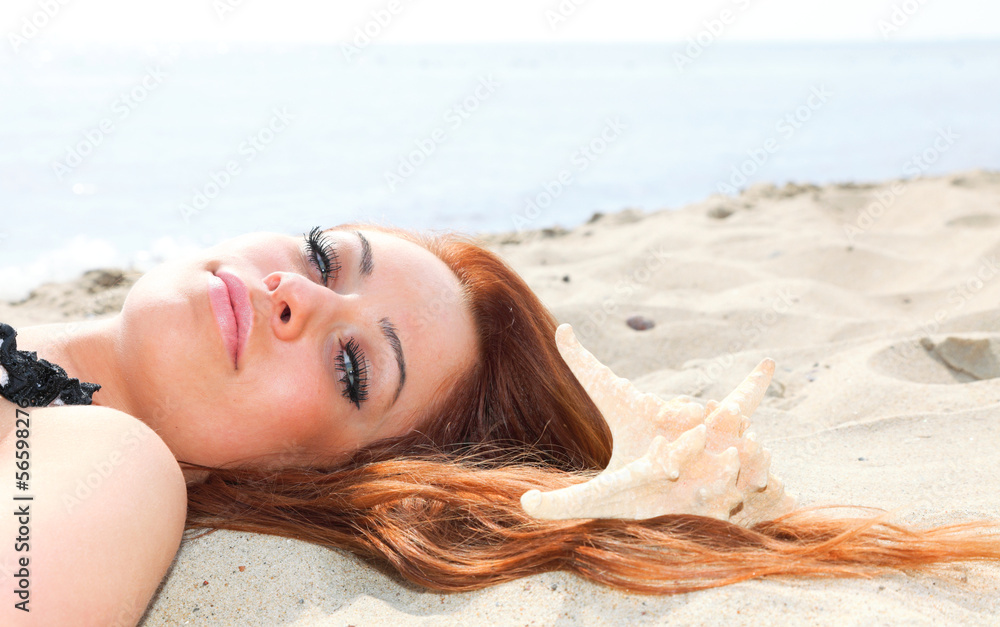 The beautiful girl lies on sea coast with shells nature vacation The beautiful girl lies on sea coast with shells nature vacation