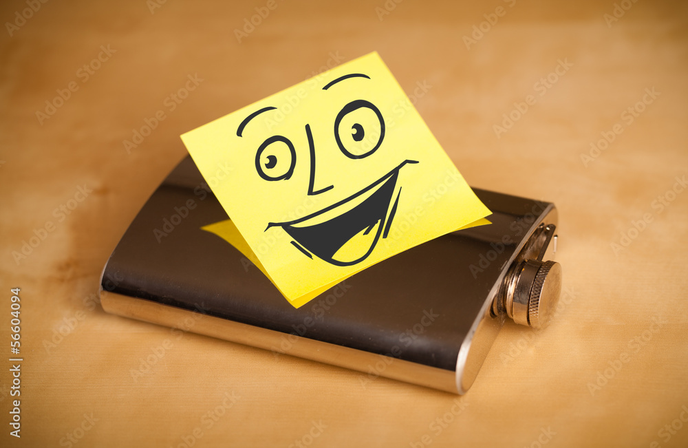 Post-it note with smiley face sticked on a hip flask Post-it note with smiley face sticked on a hip flask
