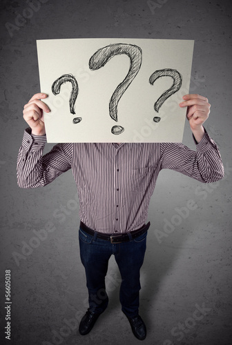 Businessman holding a paper with question marks in front of his