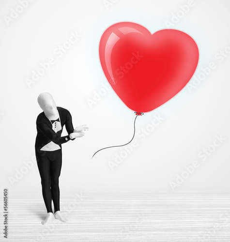 Cute guy in morpsuit body suit looking at a balloon shaped heart photo