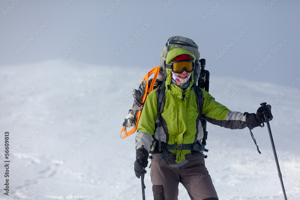 Hiker posing at camera in winter mountains