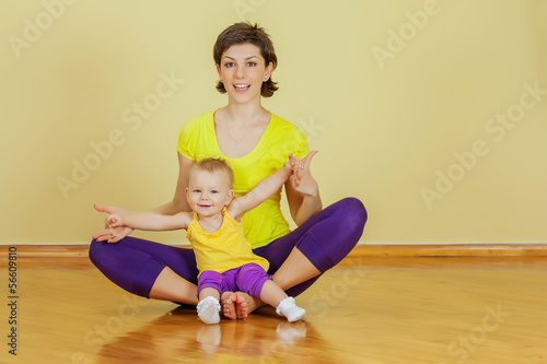 Mother do phisical exercises with her daughter at home photo