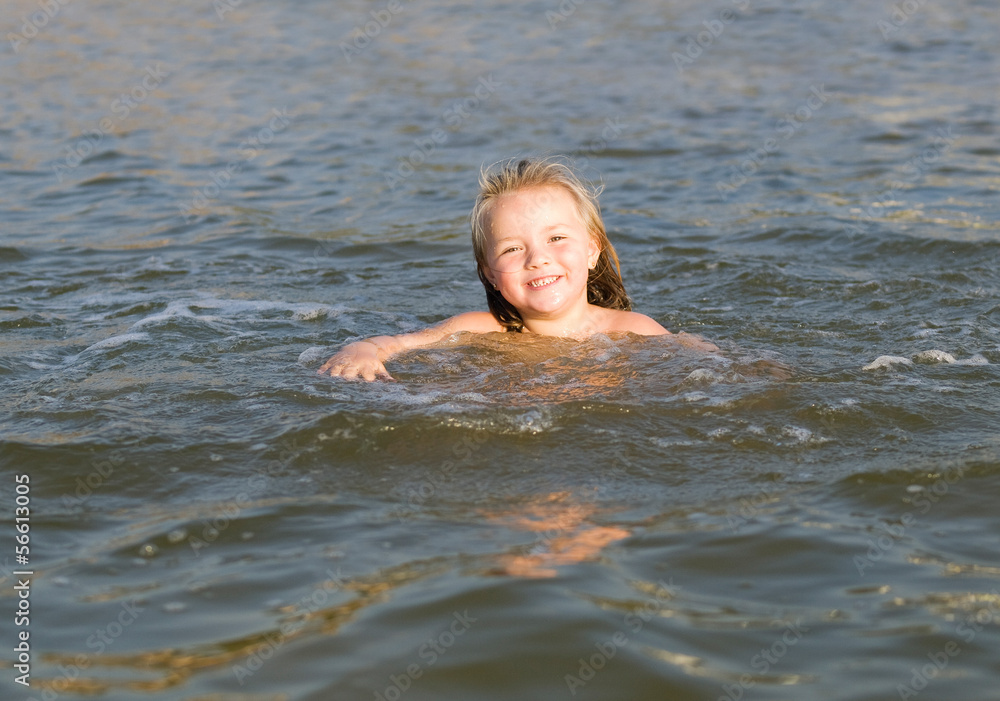 Little girl swimming at the beach