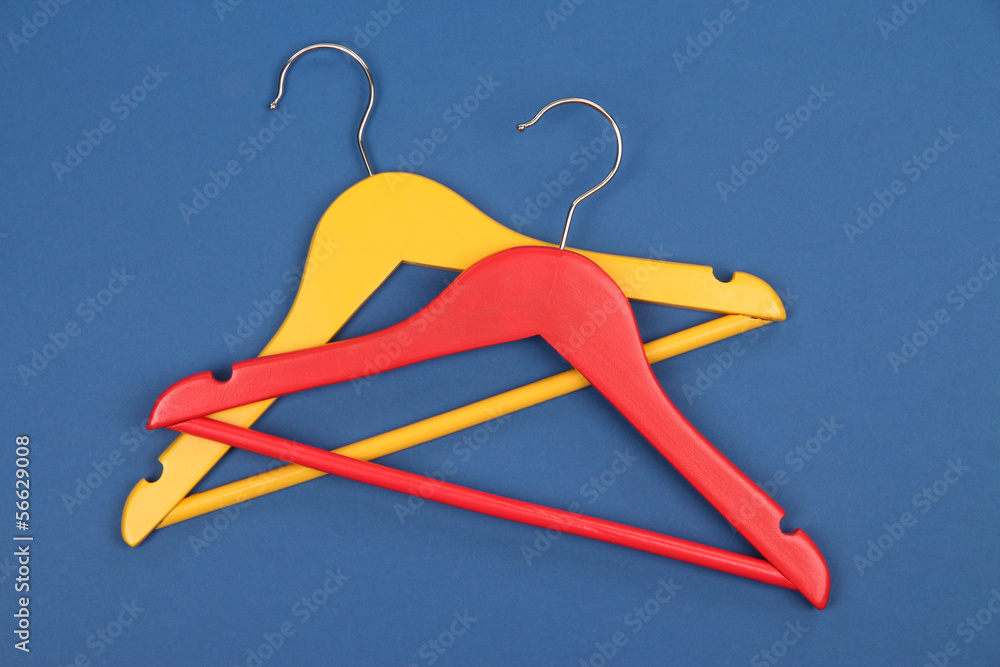 Colorful clothes hangers on blue background