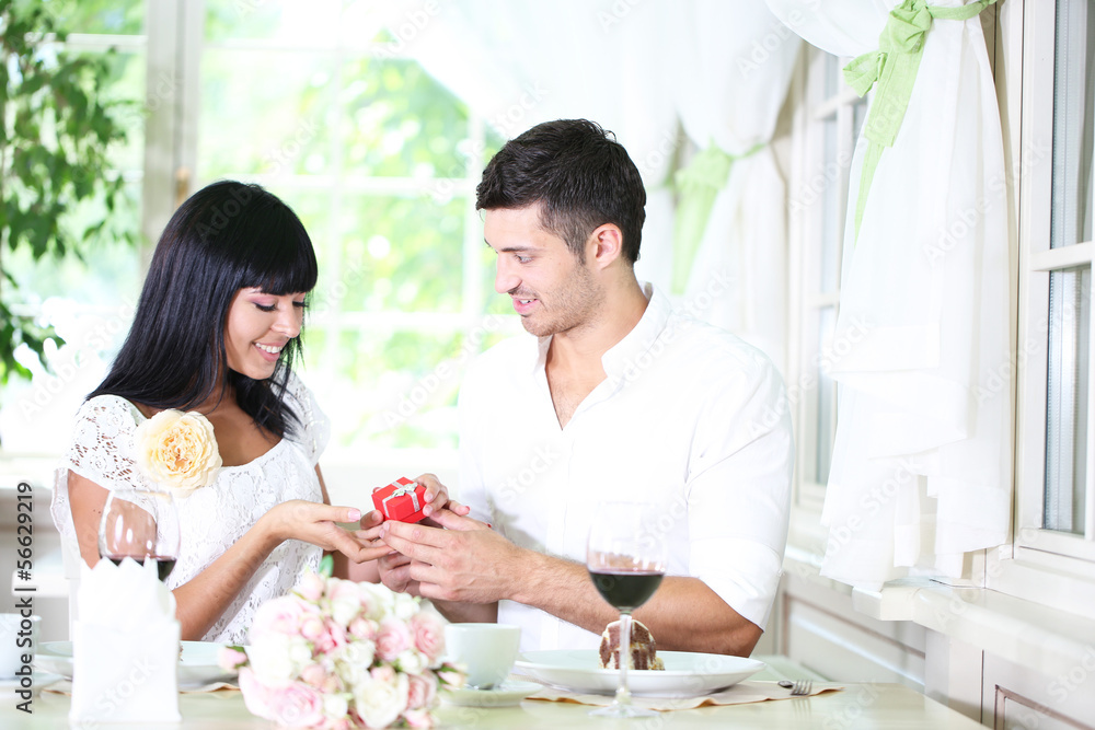 Man proposing and holding up an engagement ring his woman over Man proposing and holding up an engagement ring his woman over