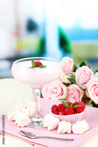 Raspberry milk dessert in cocktail glass, on bright background