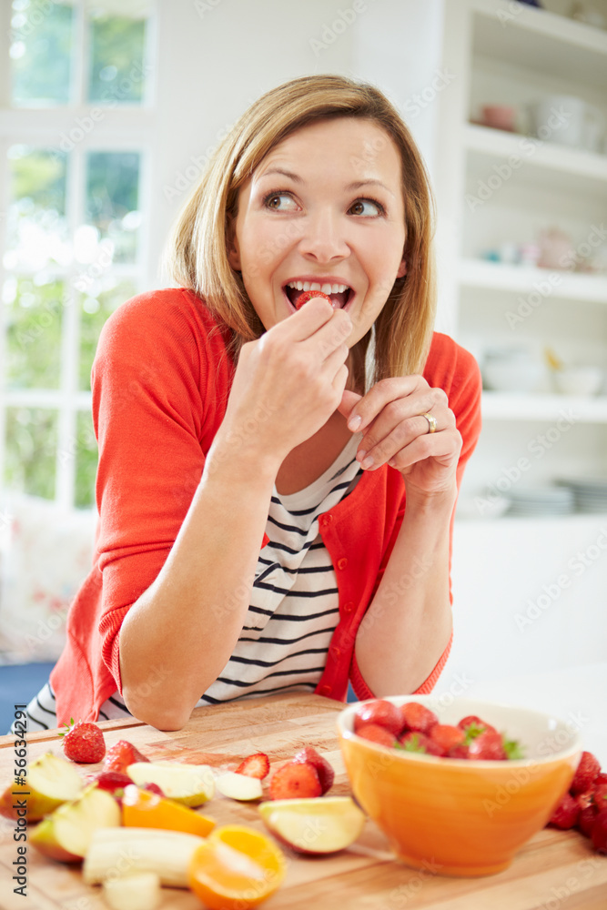 Woman Preparing Fruit Salad In Kitchen Woman Preparing Fruit Salad In Kitchen