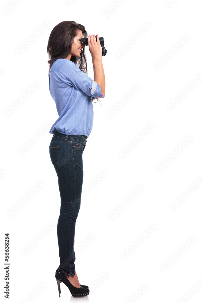 side of a casual woman looking through binoculars side of a casual woman looking through binoculars
