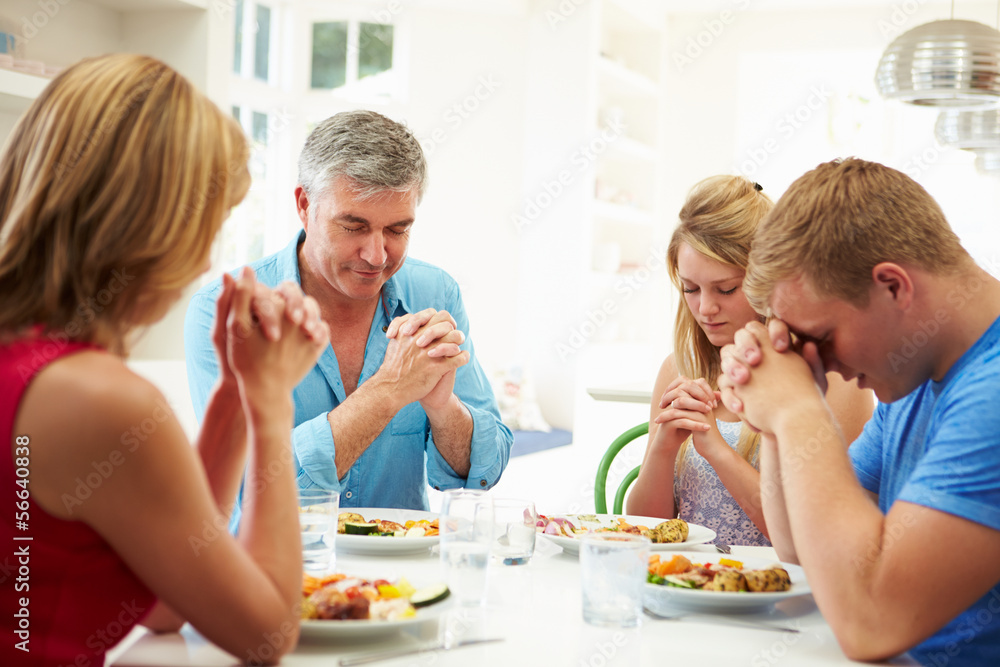 Family Saying Prayer Before Eating Meal At Home Together Family Saying Prayer Before Eating Meal At Home Together