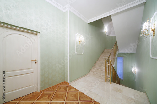 Flight of stairs, white marble stairs, green wallpaper in house photo