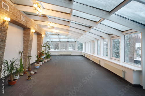 Empty conservatory with small number of plants and glass ceiling
