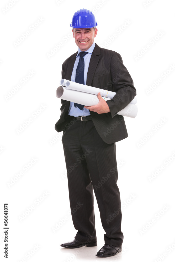 senior engineer holding some blueprints and his hand in his pock senior engineer holding some blueprints and his hand in his pock