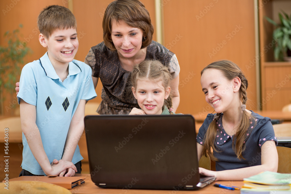 schoolchildren and teacher using laptop at lesson schoolchildren and teacher using laptop at lesson