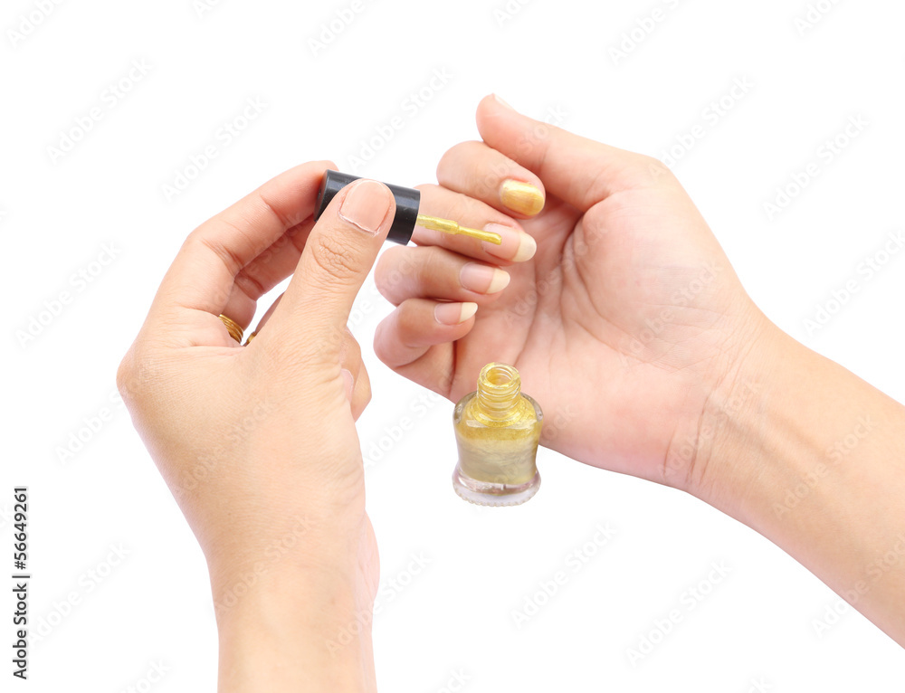 female hand with a golden nail polish on white background female hand with a golden nail polish on white background