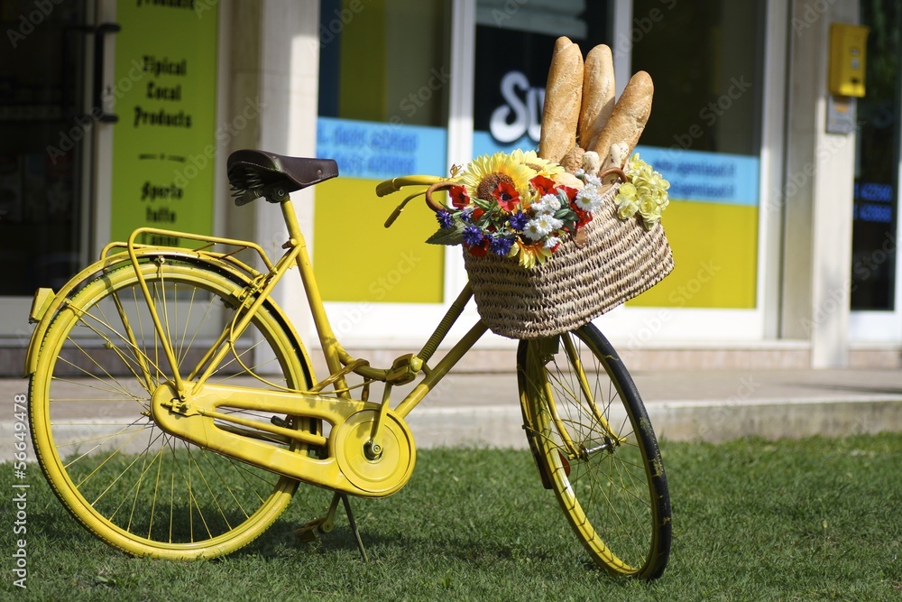 vecchia bicicletta gialla con pane e fiori sul cestino Stock Photo | Adobe  Stock