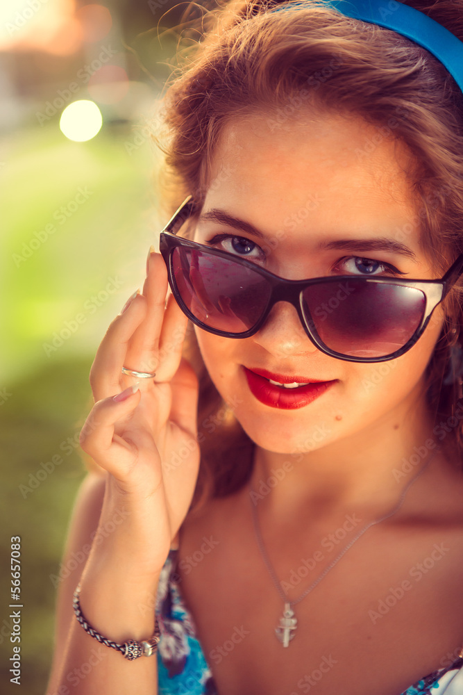 Naklejka premium American redhead girl in suglasses. Photo in 60s style.