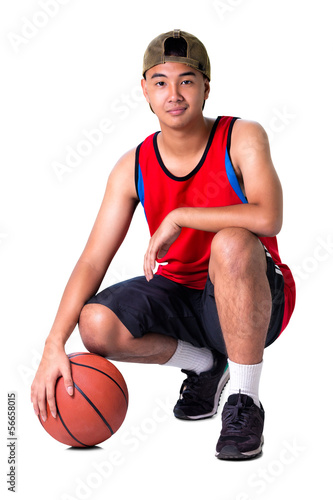 Teenager boy sitting with basketball