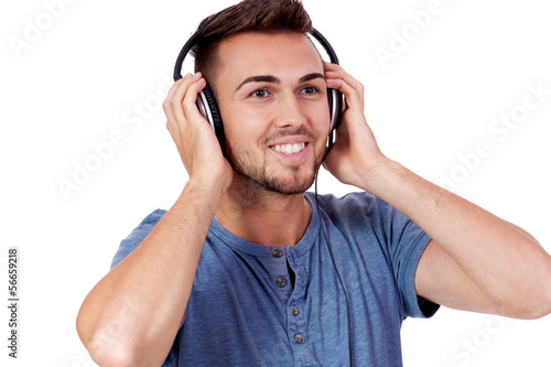junger attraktiver erwachsener mann hört musik mit kopfhörer