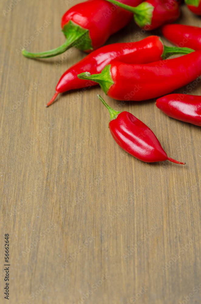 red hot chili peppers on wooden background (with space for text)