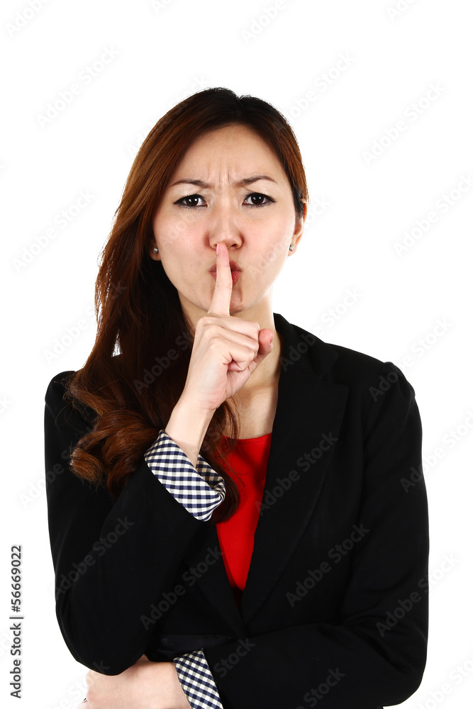 Young Asian business woman keeping finger on her lips Young Asian business woman keeping finger on her lips