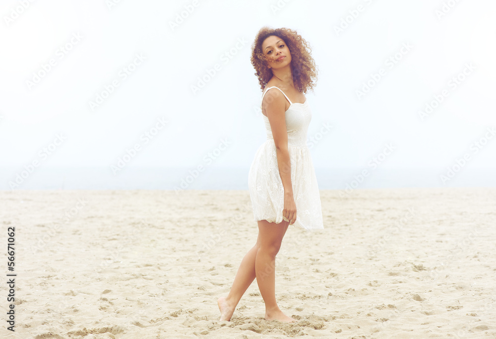 Beautiful woman in white dress walking on sand at the beach Beautiful woman in white dress walking on sand at the beach