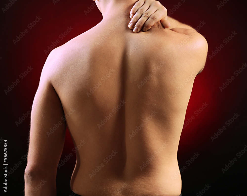 Young man with neck pain, on red background Young man with neck pain, on red background