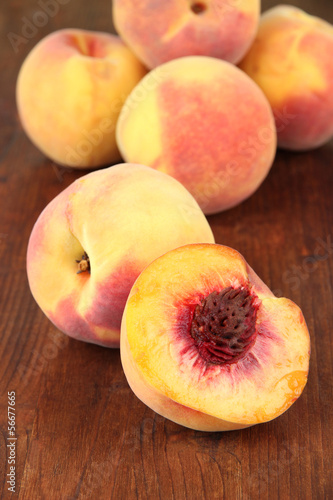Ripe sweet peaches, on wooden background