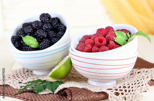 Raspberries and blackberry in small bowls