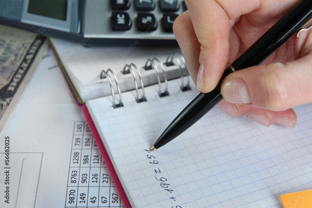 Woman hand with pen on worktable background Woman hand with pen on worktable background