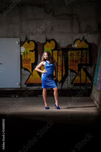 Sexy girl in blue dress posing near graffity © Кирилл Рыжов
