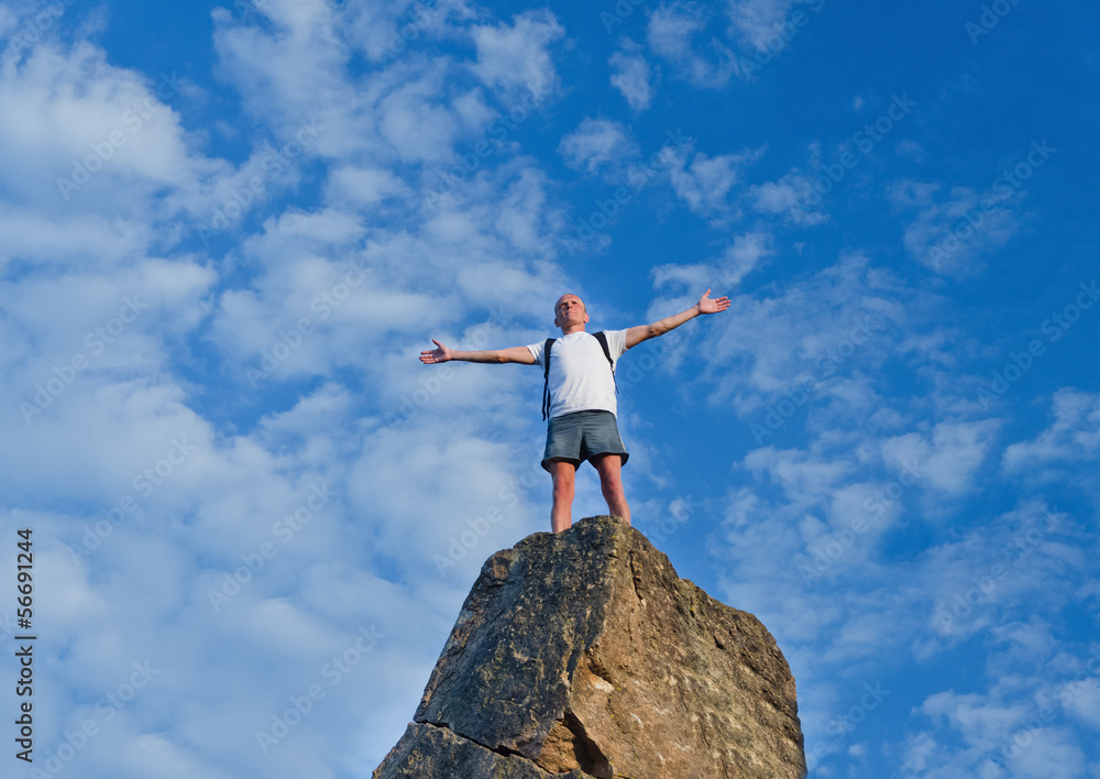Man celebrating reaching the top of a mountain Man celebrating reaching the top of a mountain