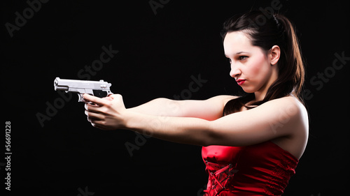 Sexy young woman - gun on black background