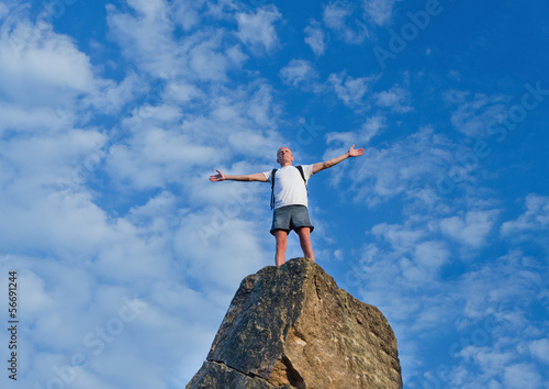 Man celebrating reaching the top of a mountain