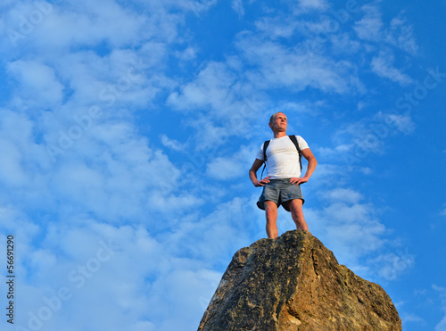 Determined man standing on mountain top