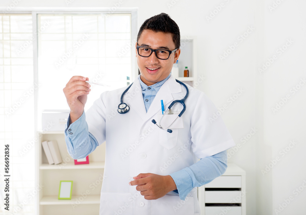 indonesian male doctor in the clinic with thermometer indonesian male doctor in the clinic with thermometer
