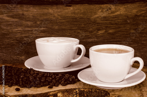 Kaffeetassen und Kaffeebohnen vor altem Holz-Hintergrund