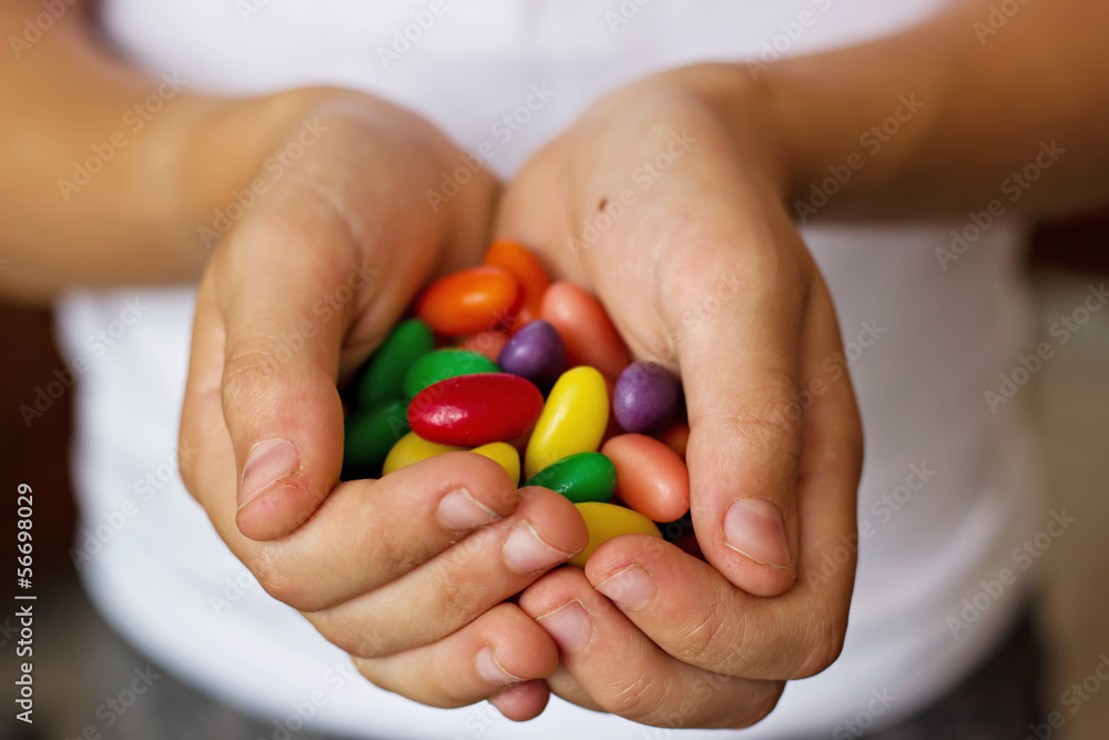 Caramelos de colores en las manos de niño Caramelos de colores en las manos de niño
