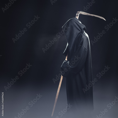death with scythe standing in the fog at night photo