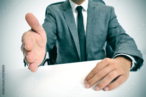 man in suit offering to shake hands photo