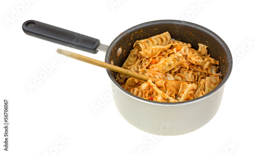 Leftover pasta with tomato sauce in a pan with a spoon