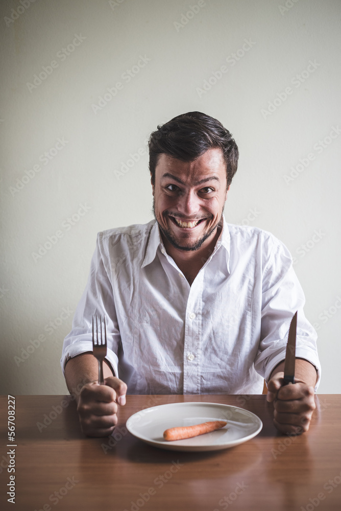 young stylish man with white shirt eating carrot young stylish man with white shirt eating carrot