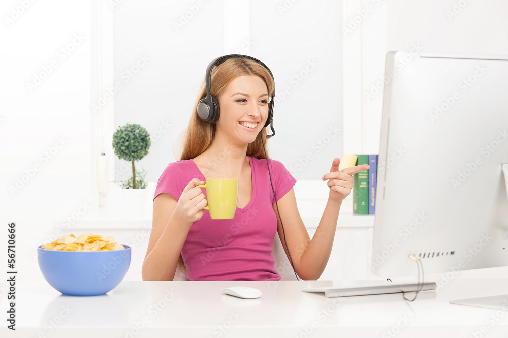 Surfing web. Beautiful young woman working at the computer and s Surfing web. Beautiful young woman working at the computer and s