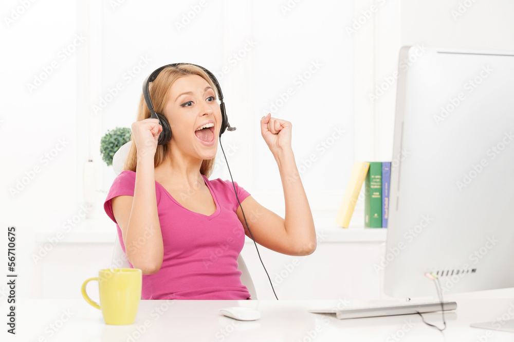 Surfing web. Cheerful young woman working at the computer and ge Surfing web. Cheerful young woman working at the computer and ge
