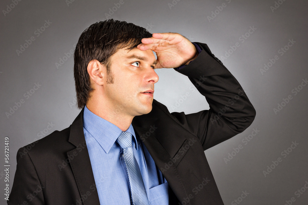 Young businessman holding his hand at forehead and looking forwa Young businessman holding his hand at forehead and looking forwa