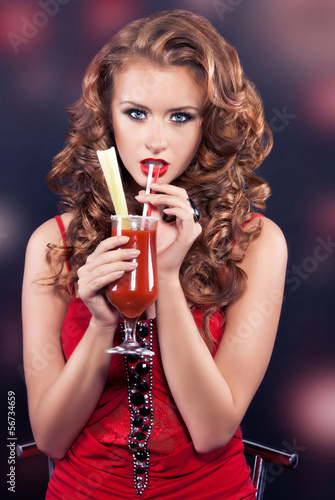 Beautiful red-haired girl in a red cocktail dress