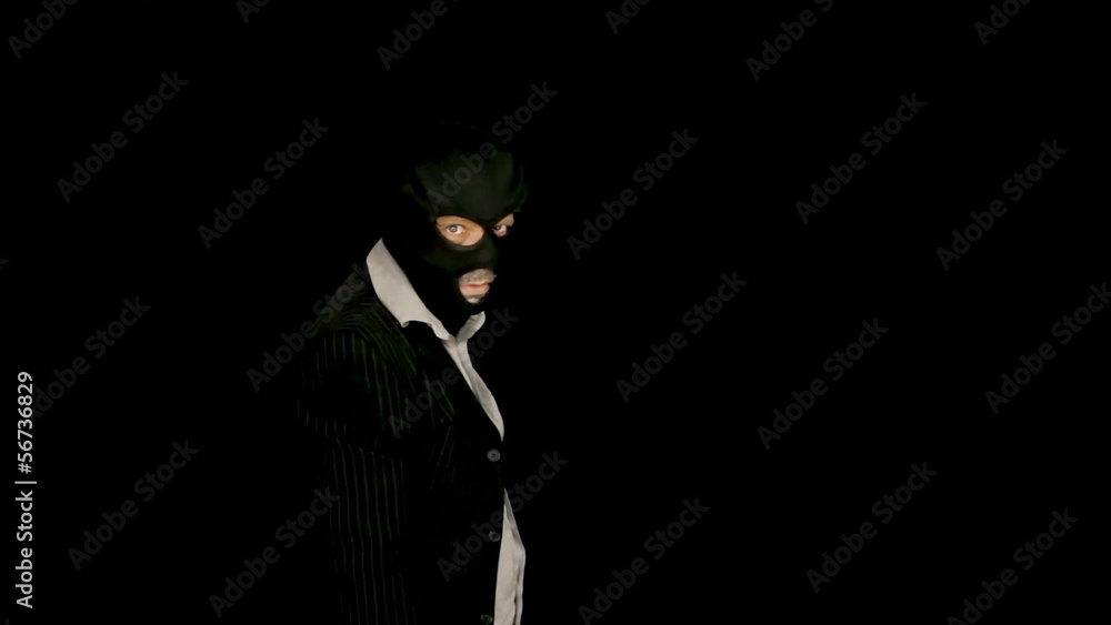 Masked criminal rising from darkness coming at viewer Masked criminal rising from darkness coming at viewer