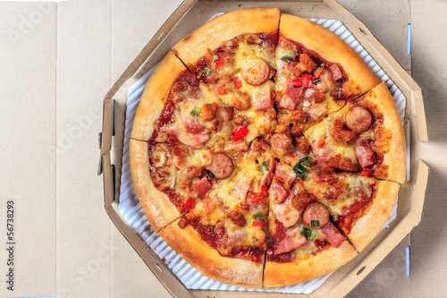 delicious pizza in a box on wooden background