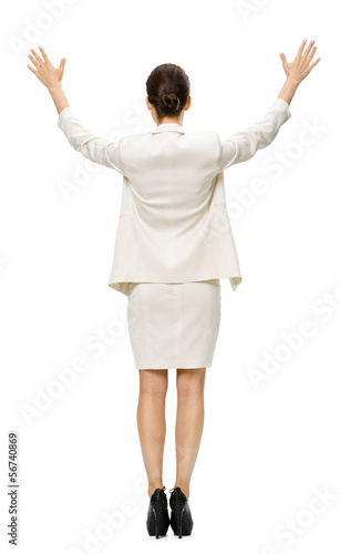 Full-length backview of businesswoman putting her hands up